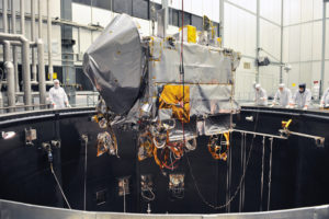 The OSIRIS-REx spacecraft being lifted into the thermal vacuum chamber at Lockheed Martin for environmental testing.